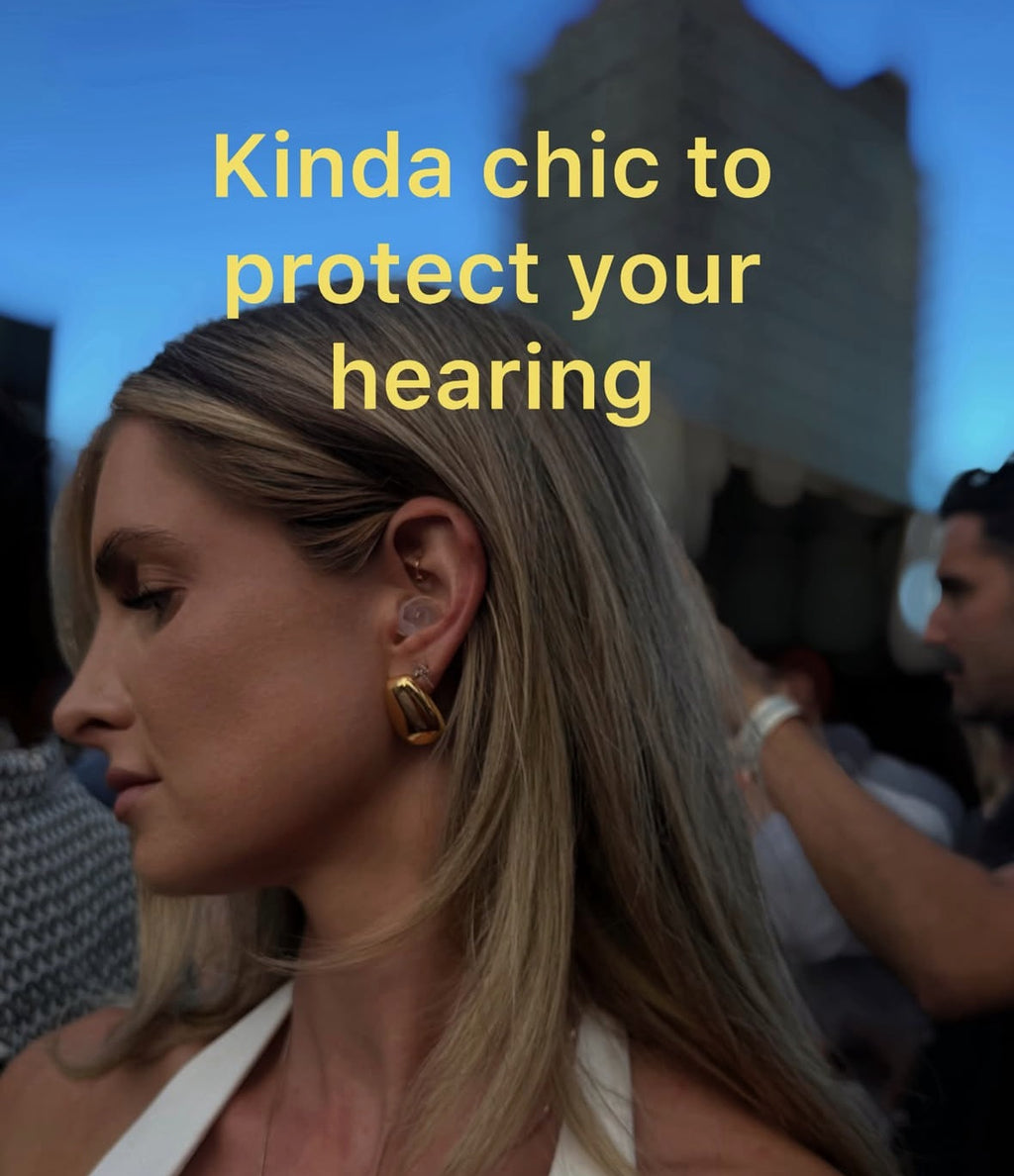 Woman at a rooftop party wearing a clear Auricula earplug